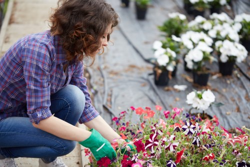 Gardener using safe working practices with tools in a managed outdoor space